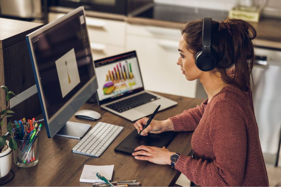 Mulher estudando marketing odontológico e tomando notas em frente a um desktop e laptop.
